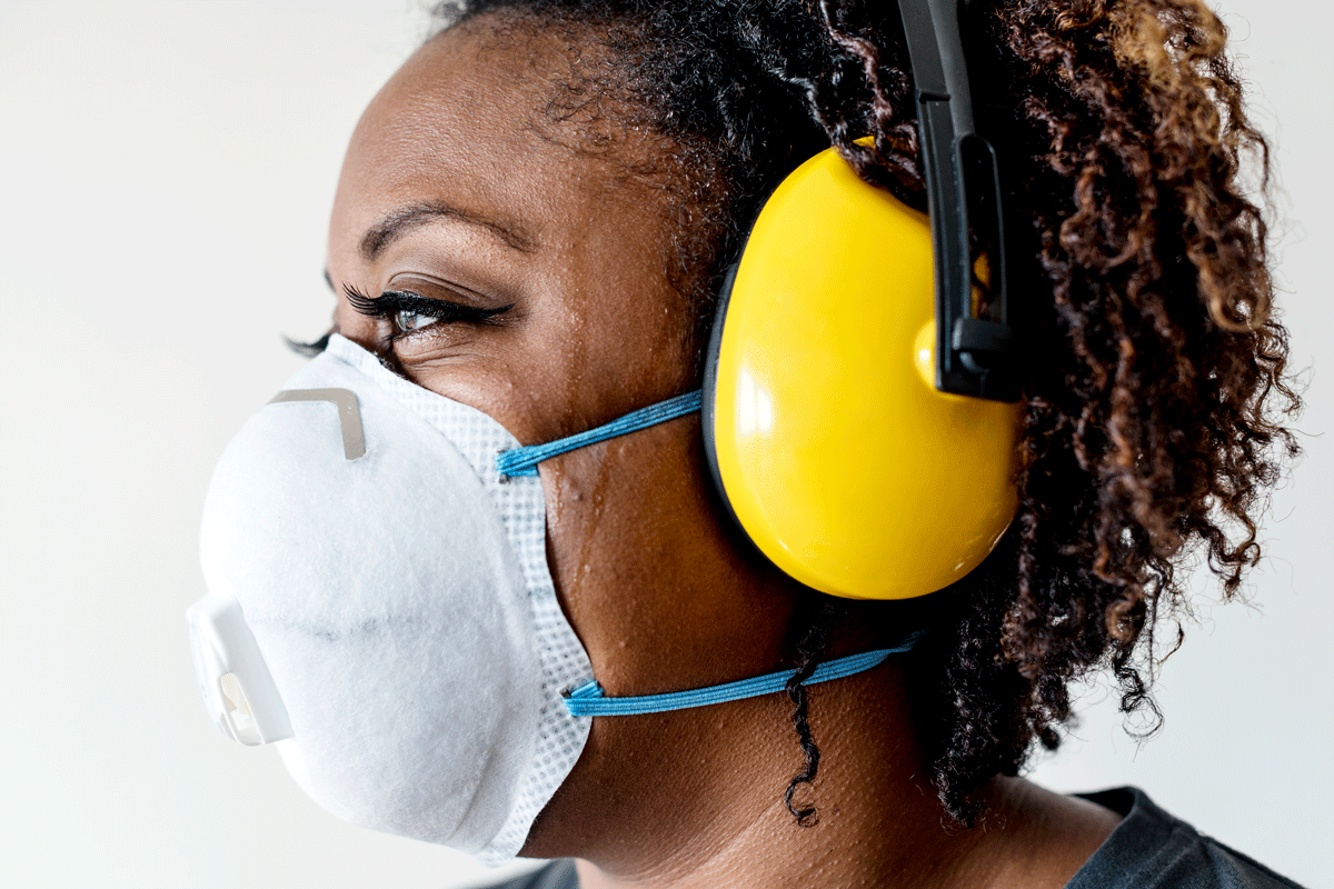 Worker wearing a properly fitted respirator with safety goggles on a job site